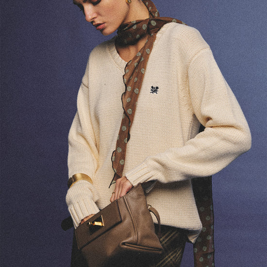 Arosris creamy khaki v-neck embroidered sweater, elegantly styled with a vintage silk scarf and plaid skirt for an effortless 90s old money aesthetic.
