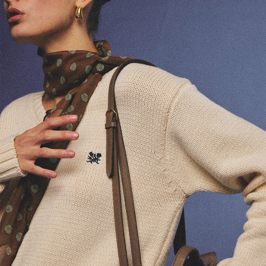Arosris creamy khaki v-neck embroidered sweater, elegantly styled with a vintage silk scarf and plaid skirt for an effortless 90s old money aesthetic.