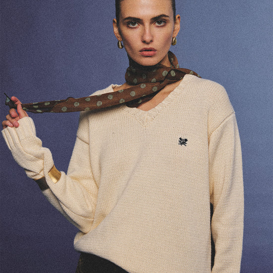 Arosris creamy khaki v-neck embroidered sweater, elegantly styled with a vintage silk scarf and plaid skirt for an effortless 90s old money aesthetic.