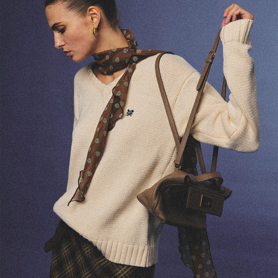 Arosris creamy khaki v-neck embroidered sweater, elegantly styled with a vintage silk scarf and plaid skirt for an effortless 90s old money aesthetic.